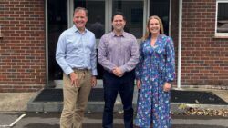 Two men and one woman standing outside actisense offices to announce Justin Cohen promotion