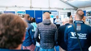 People listen to man speaking about the new marine brokers' pathway launched at SIBS 2025