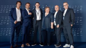 Business people in front of Ferretti blue backdrop