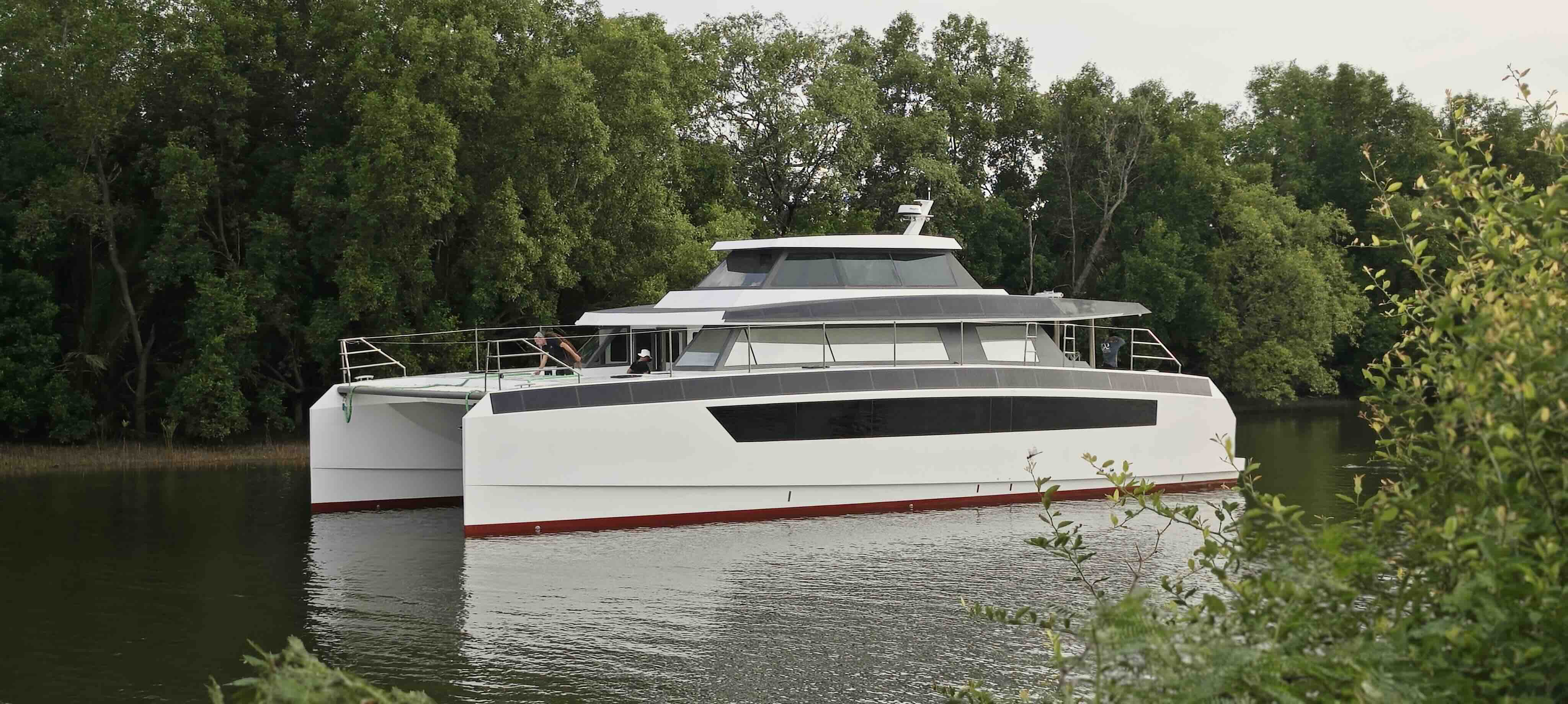 Large white luxury catamaran on a river