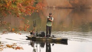 A man and a dog fishing on a Hobie vessel