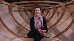 Karen Underwood sits inside the hull of a wooden Spirit Yacht