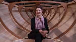 Karen Underwood sits inside the hull of a wooden Spirit Yacht