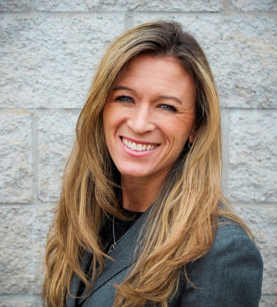 Head shot os show director for IBEX - Mary Velline - who smiles at camera