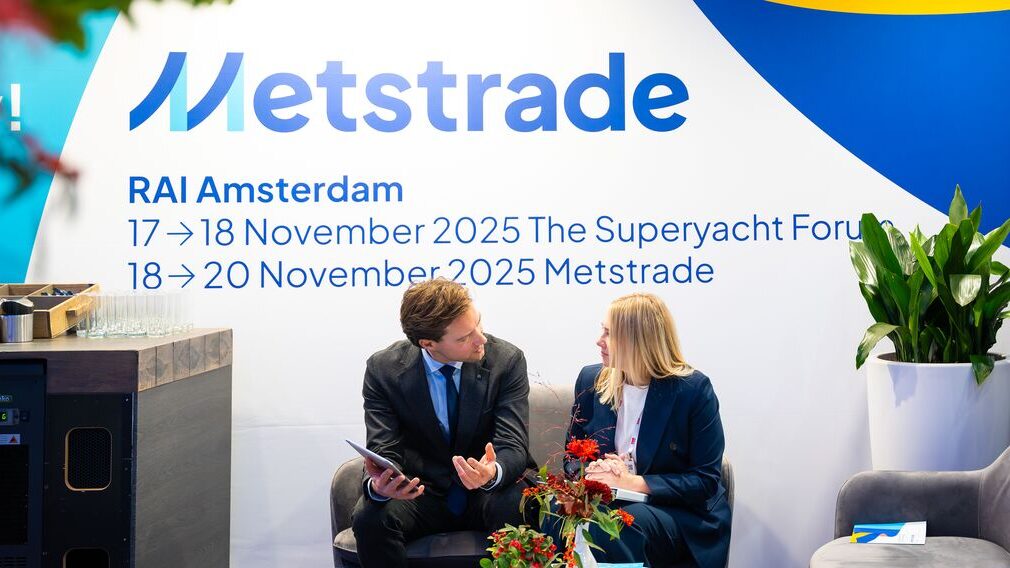 Two people in front of a banner advertising Metstrade 2025