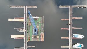 Aerial view of empty marina piers with Walcon's piling rig barge in place