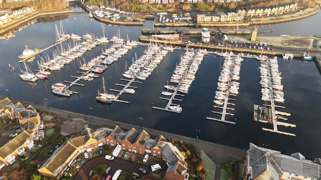 Aerial view of Royal Quays Marine with boats displayed on piers in back and housing in foreground