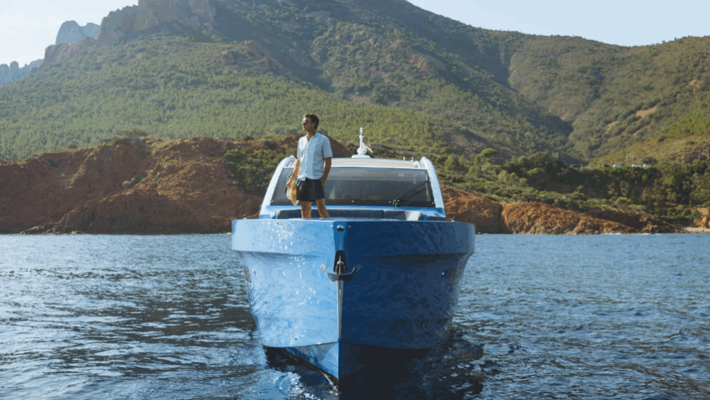 male stands in bow of Sialia Yachts' yacht with mountain behind boat as CCO talks to MIN about marine sector decarbonisation practices