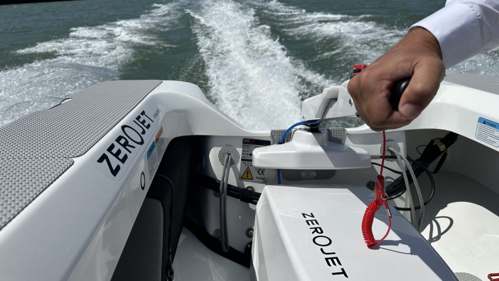 A person demonstrating ZeroJet's electric propulsion system on aft of boat