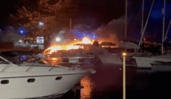 Boat on fire at night in marina