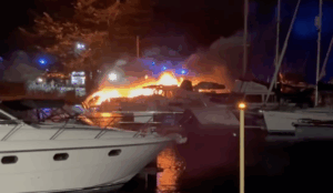 Boat on fire at night in marina