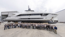43m Alia Yachts white motor yacht side profile with group of people in the foreground