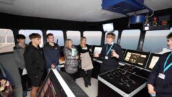 mariner student on ship's bridge talking to group of people