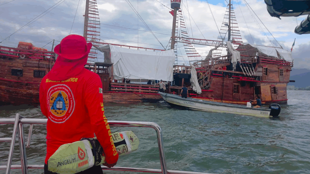 Rescue worker looks on as replica of Christopher Columbus' boat sinks