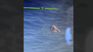 Körniges Helikopter-Rettungsbild einer Person, die auf einem Jetski auf dem Meer treibt