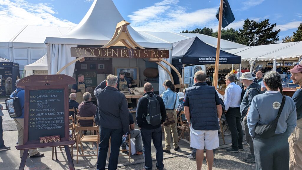 crowds gather to learn about wood as a sustainable material to build boats - they're at a stage in SIBS which Women in Boat Building conceived