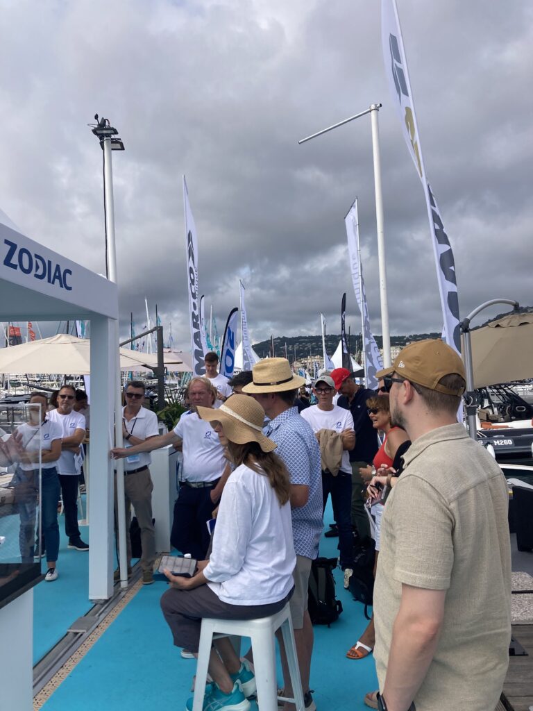 People gather on a dock at Cannes yachting festival to hear from Zodiac Nautic