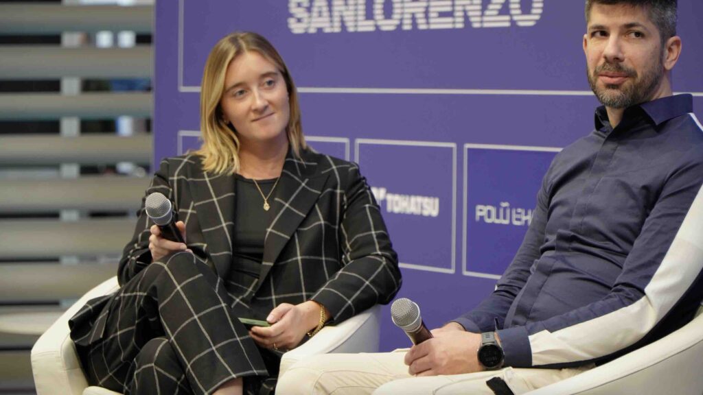 woman smiling on panel at conference stage