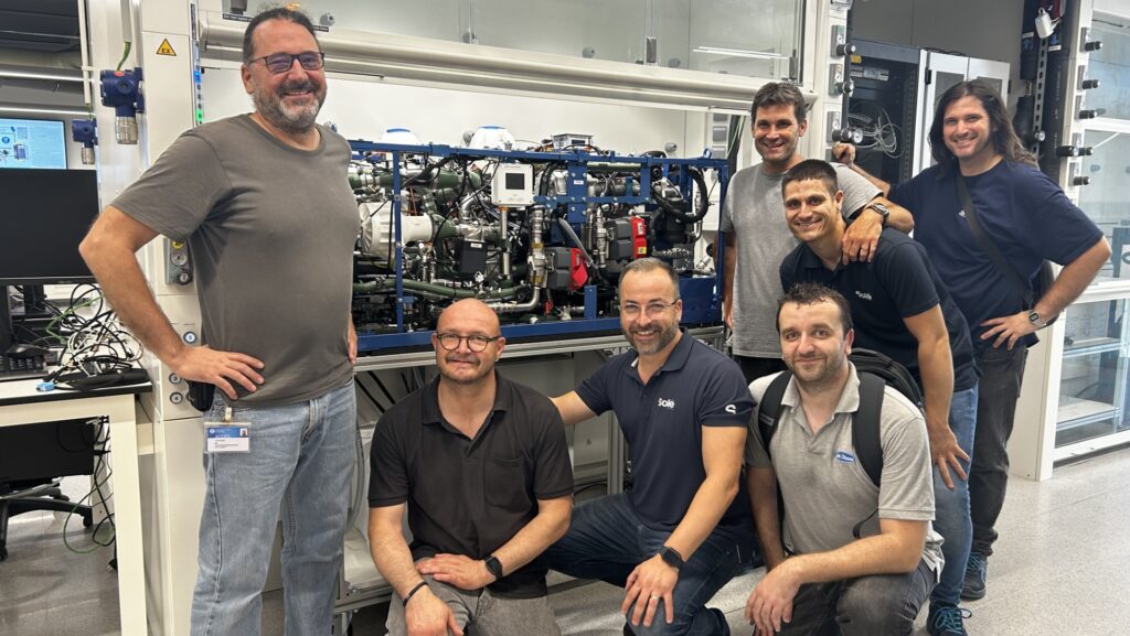 Iimage of a group of men in front of fuel cell