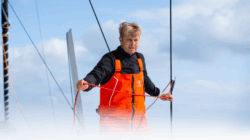 Oliver Heer dressed in orange aboard his boat