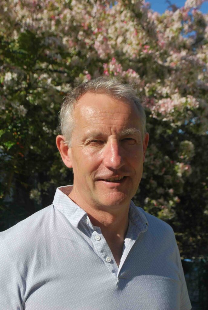 Head shot of man by tree in polo shirt