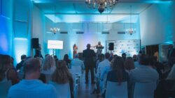 Two women on a blue stage at conference
