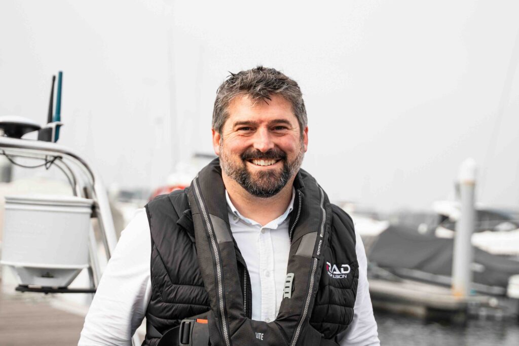 man smiling wearing black lifejacket 