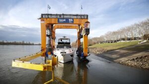 An image of big willi yacht crane moving white motor yacht