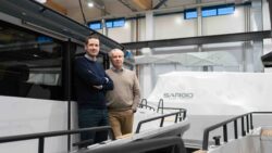 Two men standing on a boat in a factory