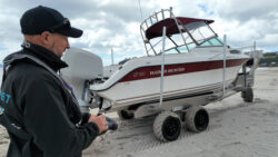 man using remote for Tectrax boat launcher