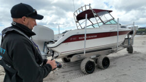 man using remote for Tectrax boat launcher