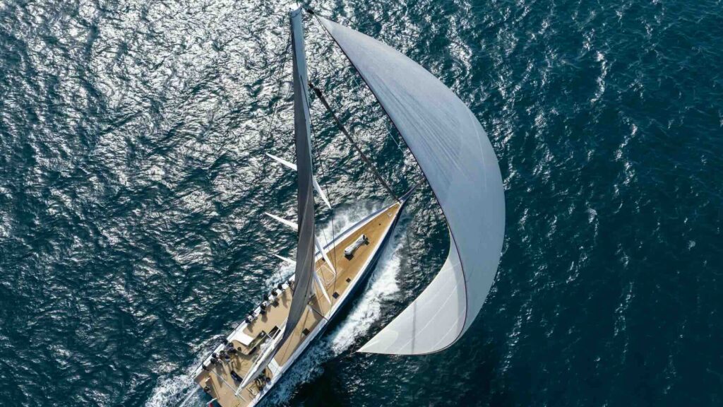 luxury yacht from above with large sail unfurled