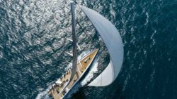 luxury yacht from above with large sail unfurled