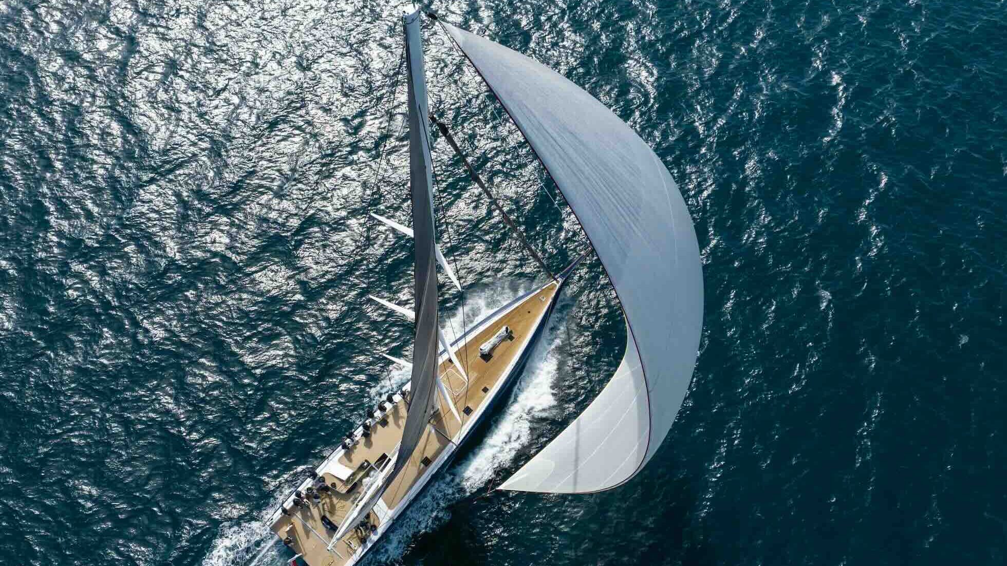 luxury yacht from above with large sail unfurled