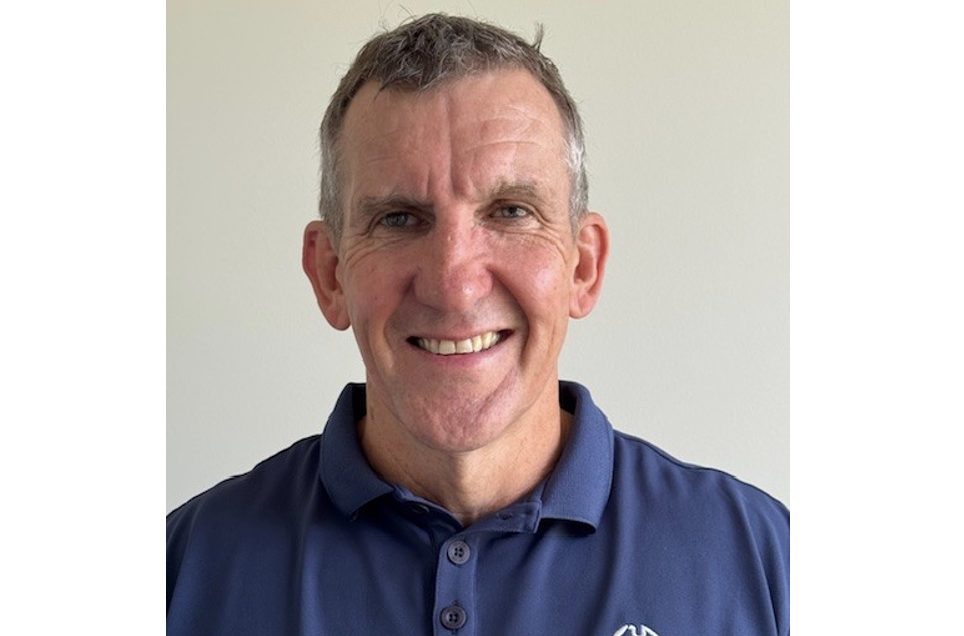 head shot of man smiling in navy polo shirt