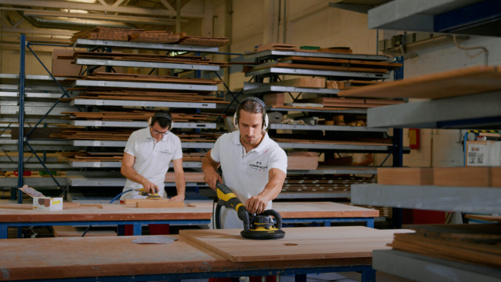 Two men work with wood in Cranchi's training academy