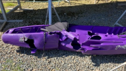 A crumpled purple kayak on the ground