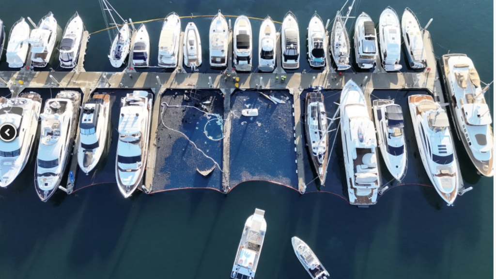 boom around sinking yacht in marina