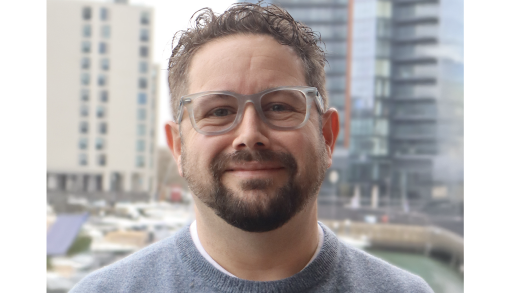 man with glasses smiling at camera