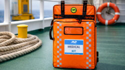 Brightly coloured medical kit bag on a deck