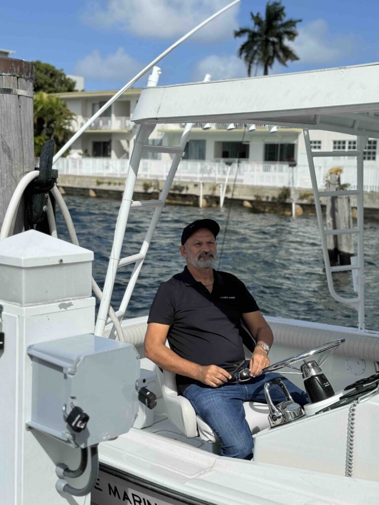 man sitting at helm of small sportfishing boat