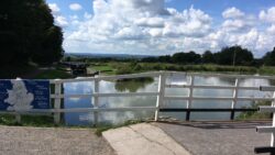 fence in front of canal lock with cloudy sky