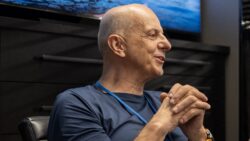 man in t shirt sits in front of screen with hands clasped together. This is Francis Lapp of Sunreef Yachts
