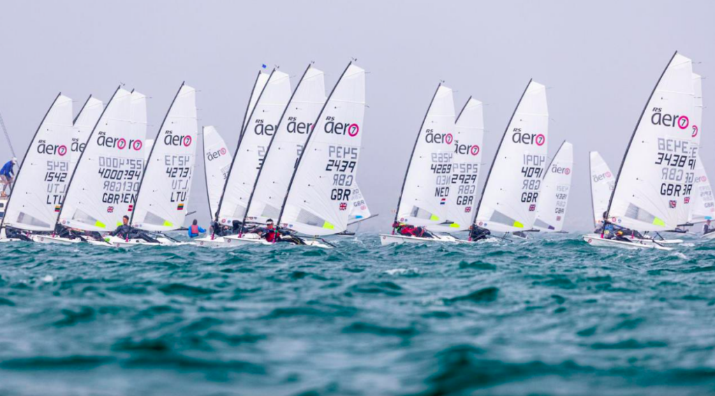 Mehrere Jollen – RS Aeros – wurden bei einer Regatta auf dem Wasser gesichtet. Alle haben weiße Segel.