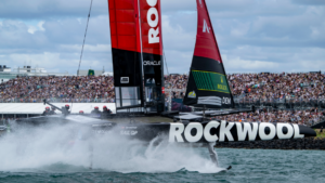 SailGP Rockwool boat speeding through water in front of grandstand of spectators