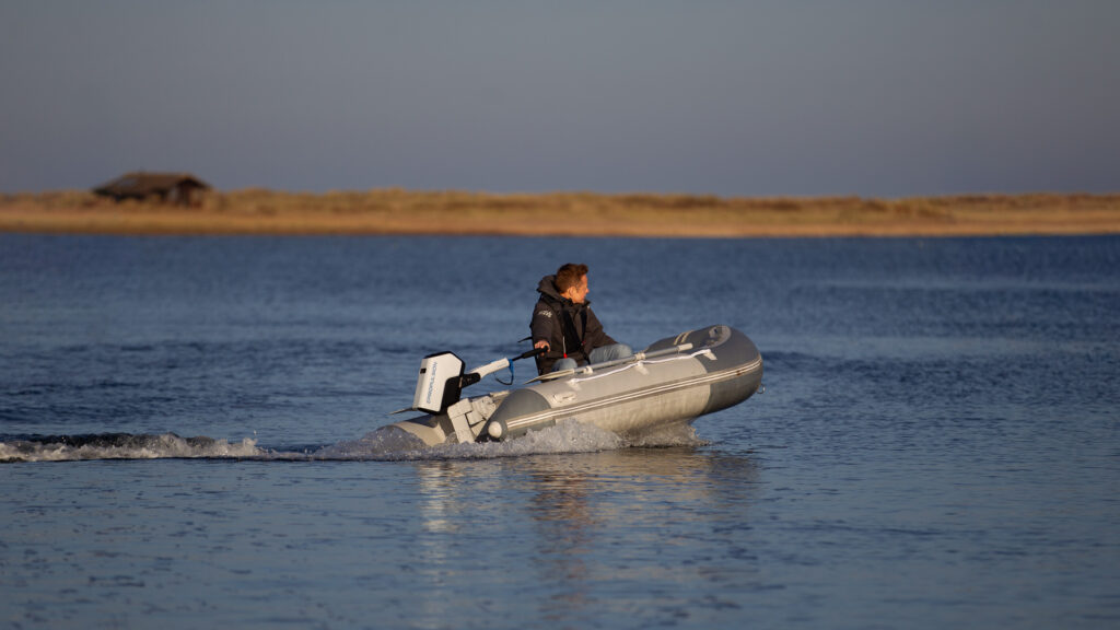 Small RIB boat on lake with electric outboard
