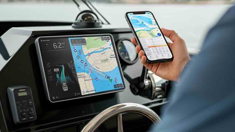 hand holding smart phone at ships helm with MFD display