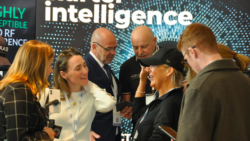 People at Superyacht Technology Show chat under a banner that says 'intelligence'
