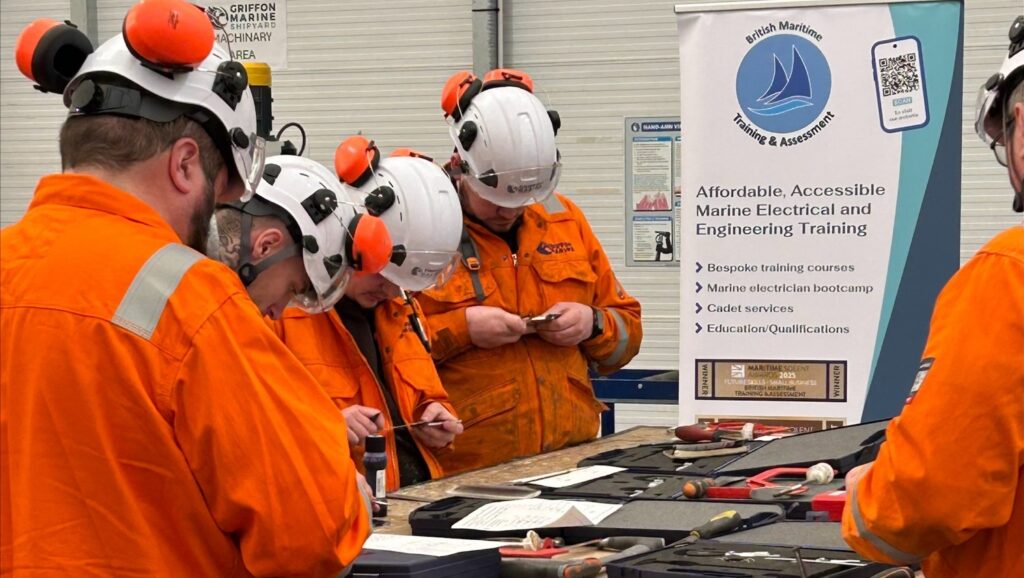 Students in orange PPE stand around a table