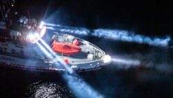 Workboat at night with headlights on